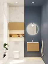 Kleine, stijlvolle badkamer met donkerblauwe muren, zachte gele badkamermeubels met groeven en een elegante ronde spiegel met lamp