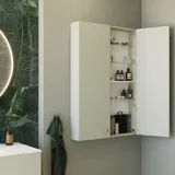 Stijlvolle en luxueuze badkamer met zachte groene tinten, een grote elegante ronde spiegel en een modern, verfijnd groen toilet