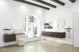 Badkamer inspiratie in noordse stijl met wastafelmeubel en onderkasten in gerookt eiken, make-up ruimte, zij-aangebracht wastafel, ronde spiegel met messing frame en zichtbare charmante houten balken