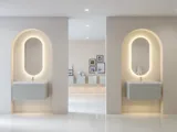 Stijlvolle en moderne badkamer inspiratie met ovale spiegels met lichtregeling, stenen wastafels en wastafelmeubels met elegante groeven in een minimalistisch ontwerp, lichte en luchtige sfeer met elegante verlichting en verfijnde details