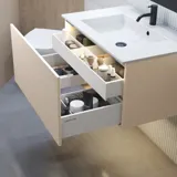 Stijlvolle badkamer inspiratie met beige wastafelmeubel met binnenlade, bovenkast, open plank, ovale spiegel met verlichting, bijpassende hanglampen, plank onder de spiegel en wandgemonteerd toilet. Wanden met lichte, langwerpige tegels