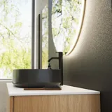 Minimalistische en stijlvolle badkamer inspiratie met wastafelmeubel, onderkasten en hoge kasten in gouden eik, grote ronde spiegel met lichtregeling, gekleurd toilet en vrijstaande wastafel